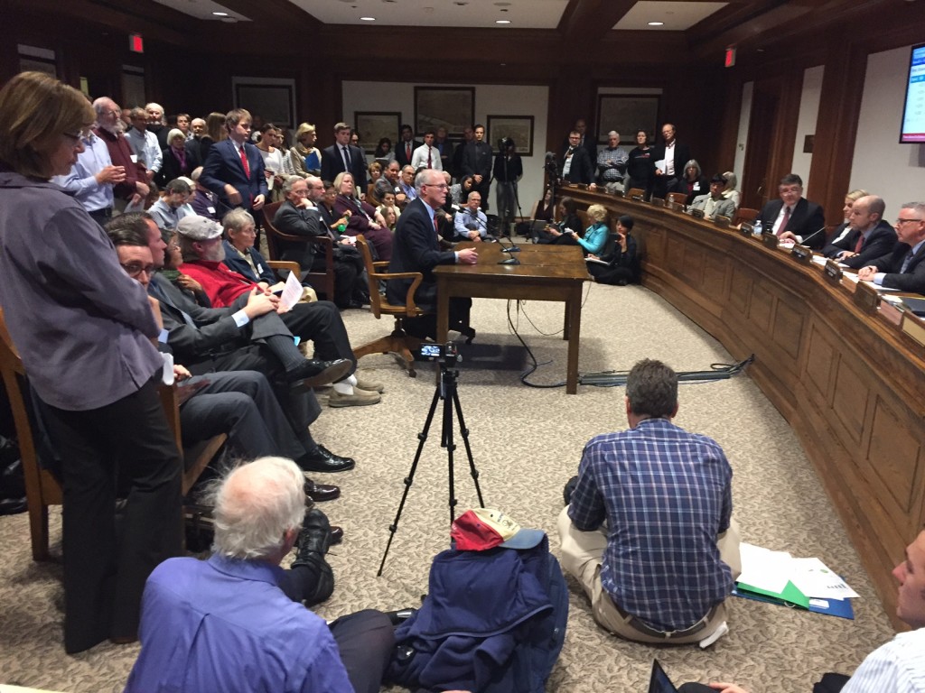Sen. Barrett testifies on carbon pricing at a packed committee hearing.