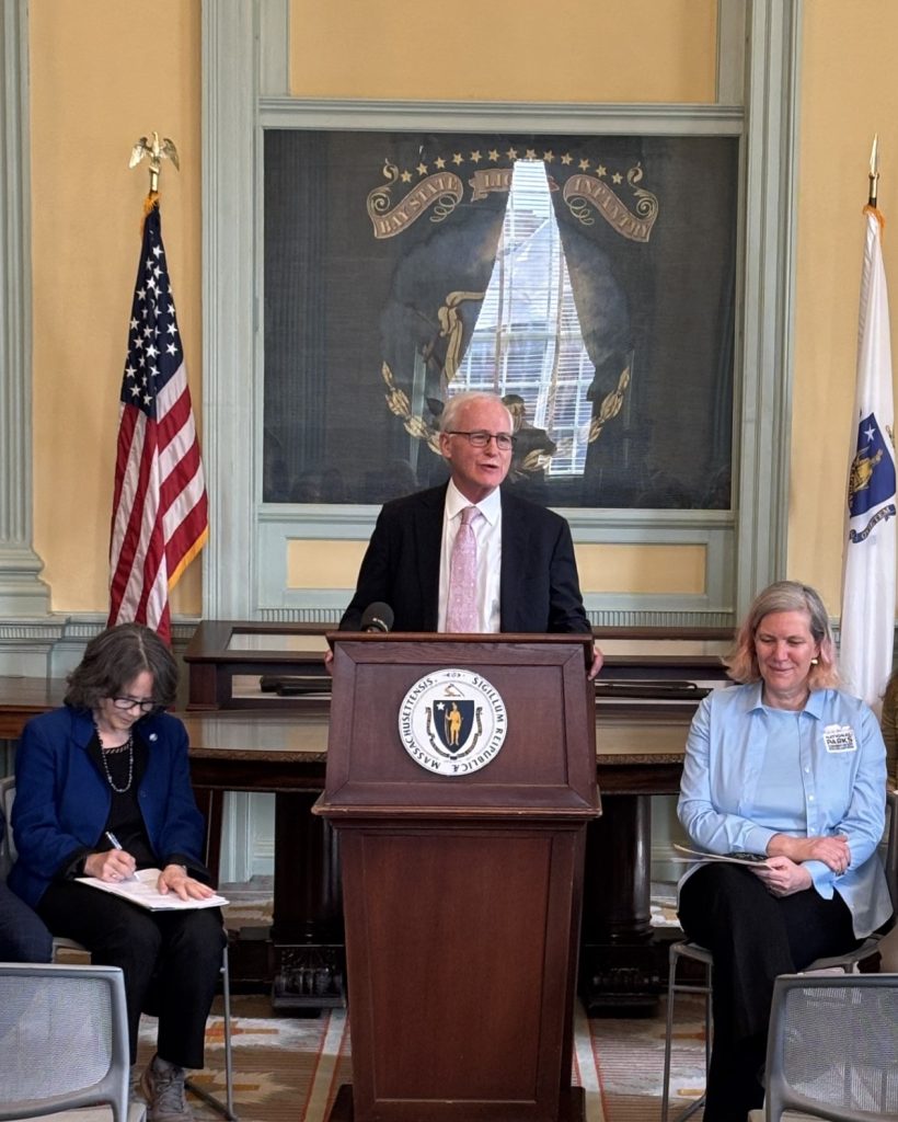 Senator Barrett speaks at a podium in the State House