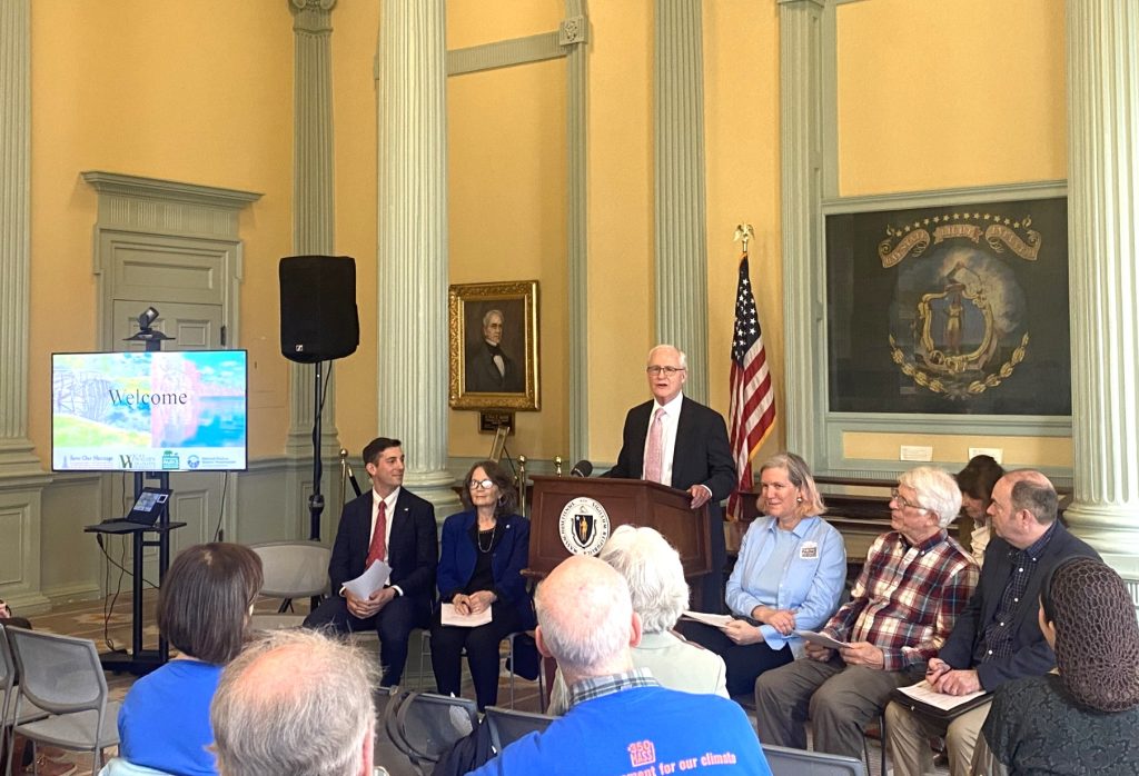 Senator Barrett speaks at a podium in the State House (wide shot)