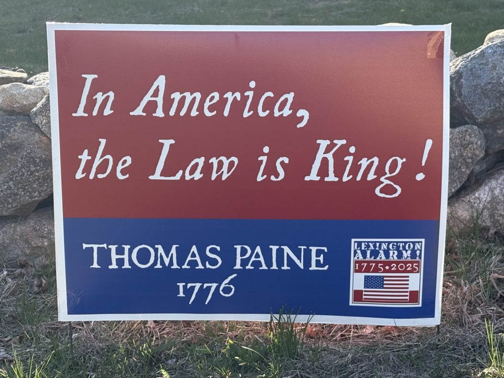 A picture of a sign that reads. "In America, the Law is King! - Thomas Paine, 1776"