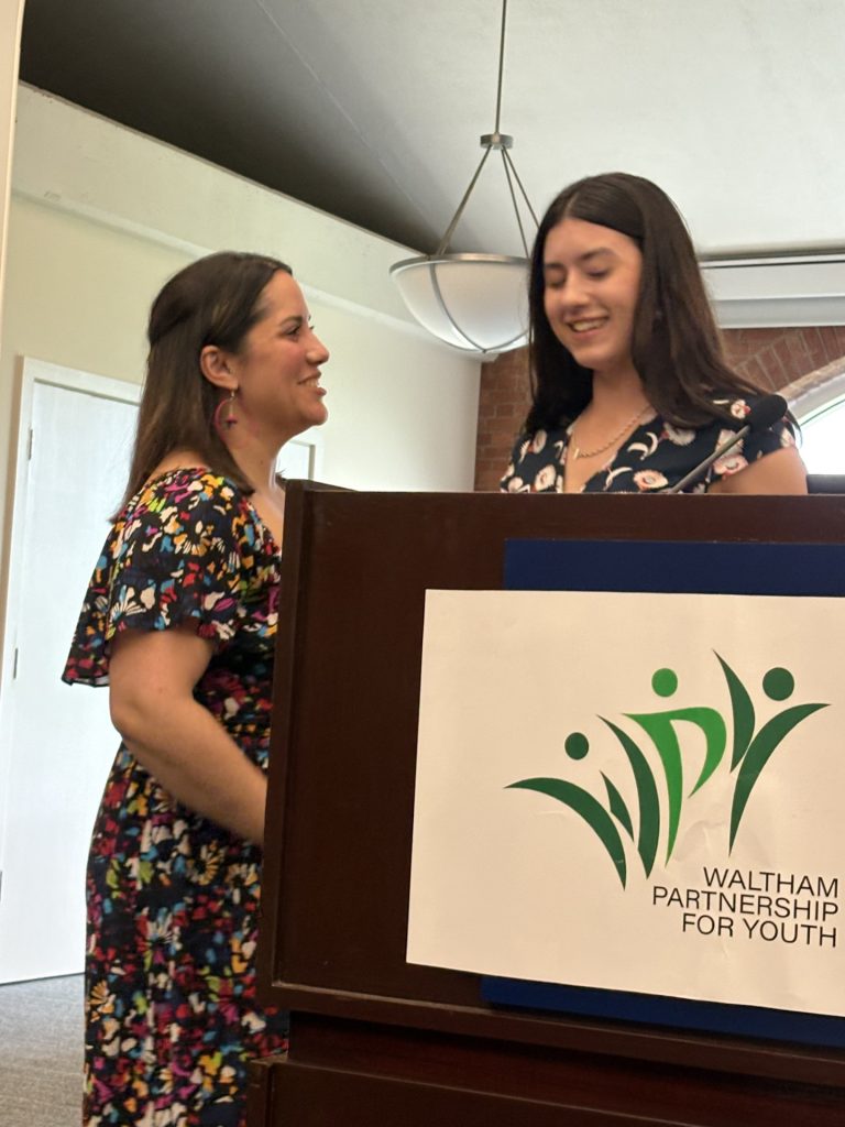 Magali Garcia-Pletsch congratulates student speaker at WPY event.