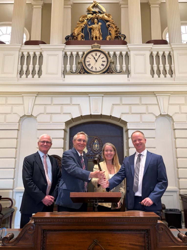 Senator Barrett stands in the Senate chamber with Gib Metcalf, Bethany Patten, and Chris Knittel