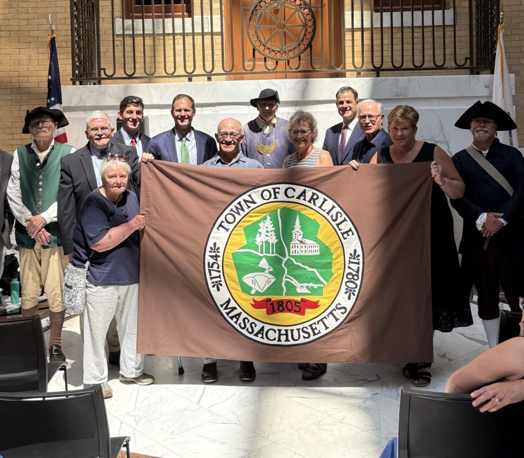 Senator Barrett stands with Carlisle officials behind Carlisle's official flag